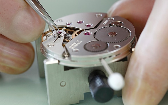 Reparación de un reloj de pulsera mecánico en una fábrica relojera en Grenchen.