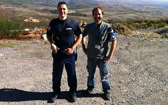 Two men in a gravel yard in Kosovo. 