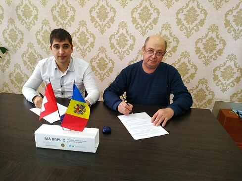 Moyors Vasili Capsamun (left) and Oleg Sandu (right) signing the cooperation agreement between their villages