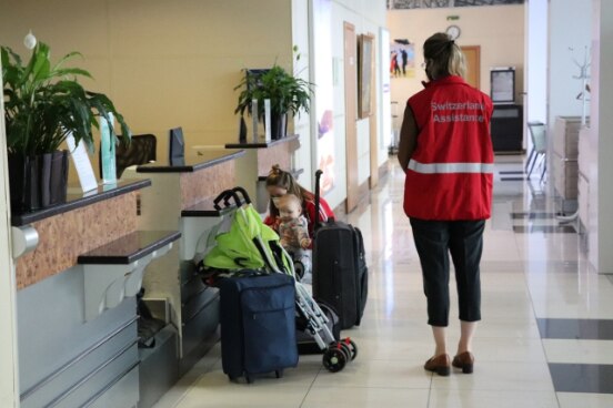 Représentante de l’ambassade et famille avant le vol humanitaire