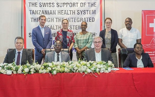 From L to R (seated): Ambassador Didier Chassot, Deputy Minister for Health Dr. Godwin Mollel, Mr. Manfred Stoermer and PO-RALG representative Ms. Subisye Kabuje with development partners (back row). 