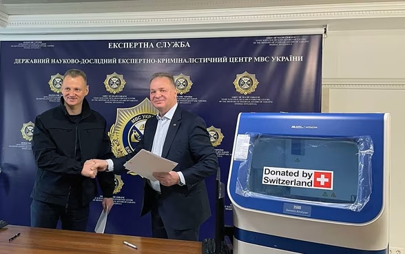 Клод Вільд, колишній посол Швейцарії в Україні, передає обладнання для аналізу ДНК директору Державного науково-дослідного експертно-криміналістичного центру в Києві в лютому 2023 року. 