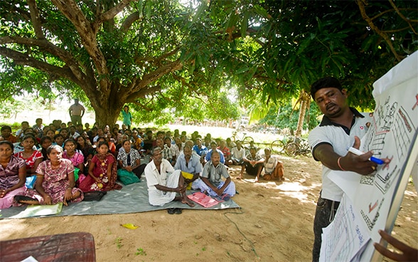 With the aid of a diagram, an SDC expert consults around 50 Sri Lankan villagers to find out what rebuilding work is needed.