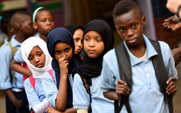 Bambini e giovani di vari Paesi camminano in una fila ordinata.