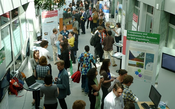 Visitors to the Research Fair walking around and talking to each other at the various stands.