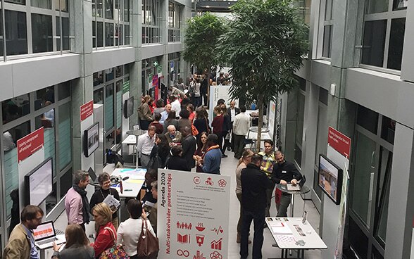 Visitors to the Research Fair walking around and talking to each other at the various stands.