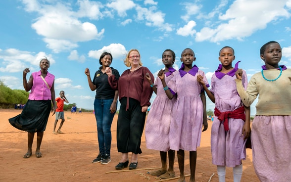Katja Iversen participating and dancing with African girls in a ceremony in Kenya. 