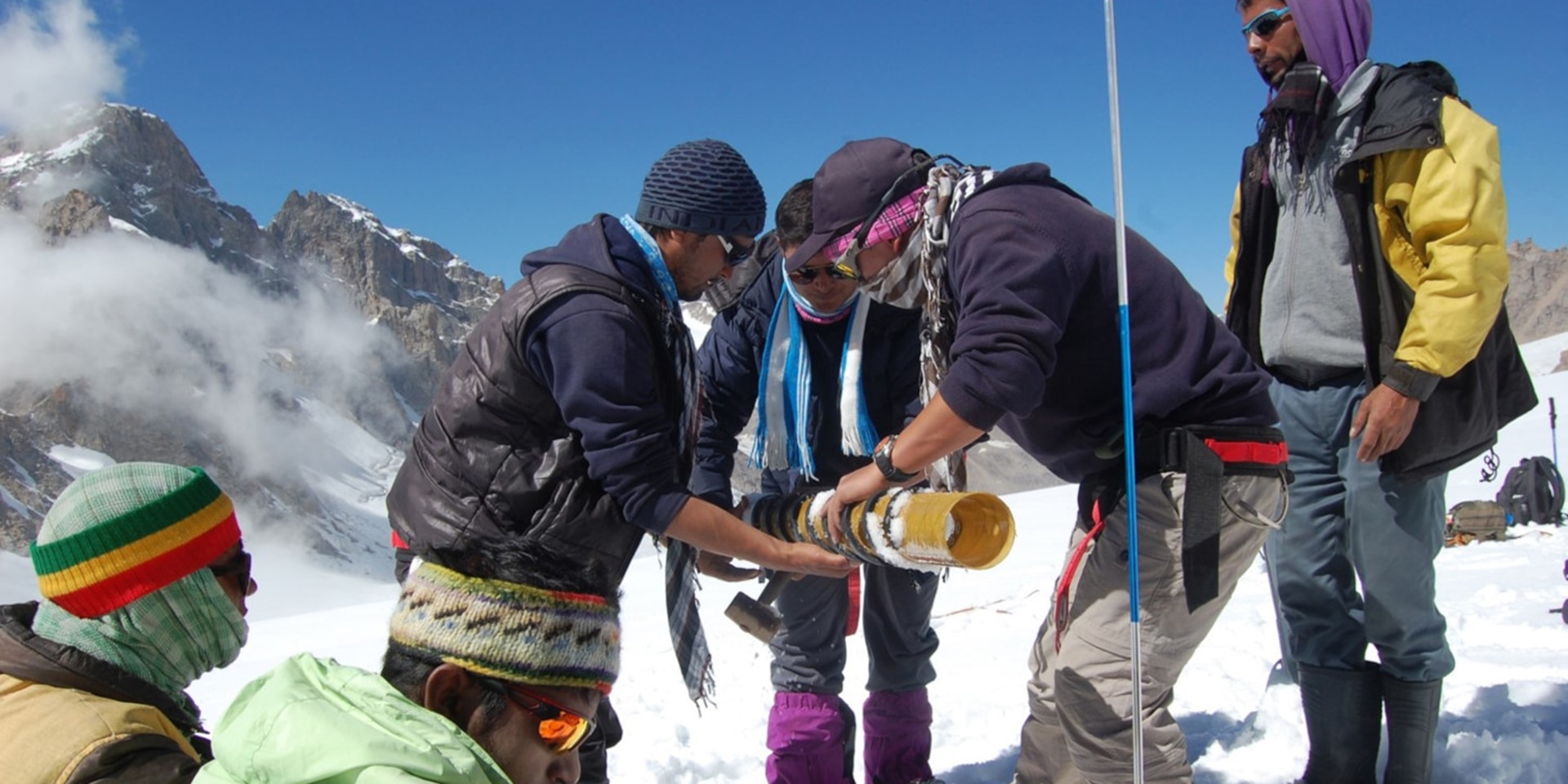  On a snowy mountain, a group of young people are positioning material to monitor glaciers. 