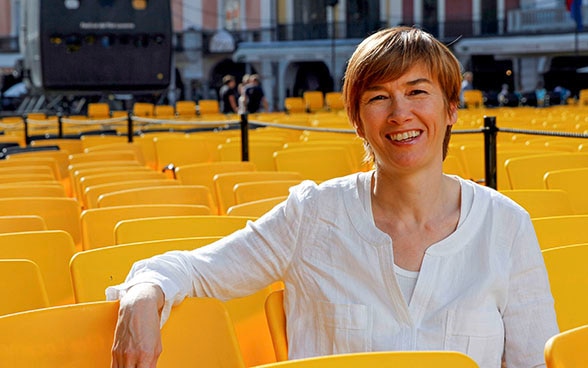 Sophie Bourdon, responsable de la section Open Doors, est assise sur l’une des nombreuses chaises jaunes disposées sur la Piazza grande à l’occasion du Festival du film de Locarno.