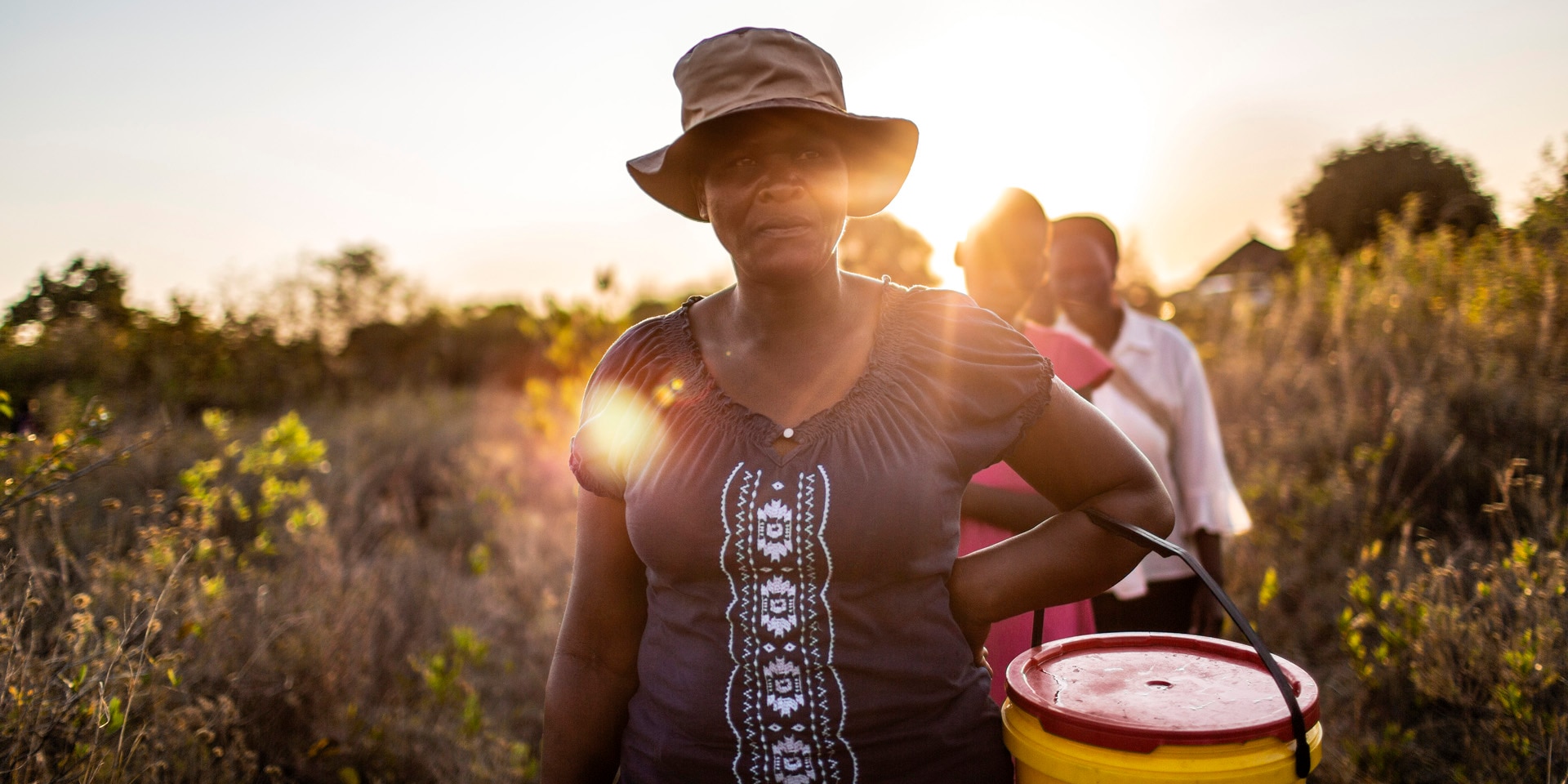 A woman carries a bucket of water.