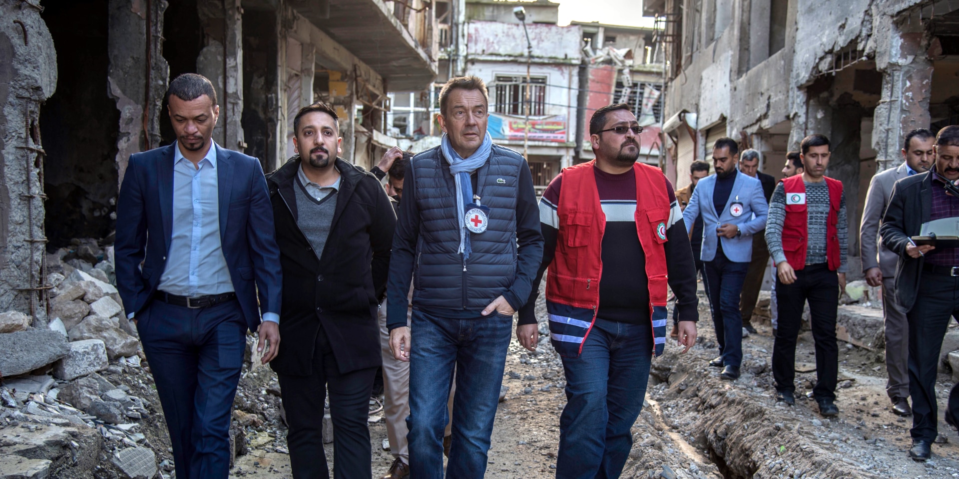 Peter Maurer visita un barrio marcado por la destrucción con empleados del CICR y de la Media Luna Roja.