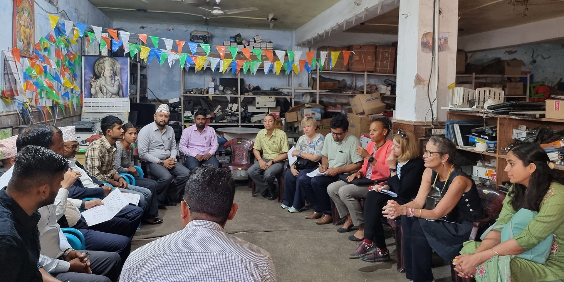 La directora de la COSUDE, Patricia Danzi, de visita en un centro de formación informática en Nepal. Los participantes en la discusión se sientan en círculo. Entre ellos hay dos estudiantes.