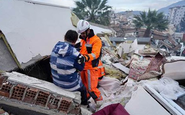 Un membro della Catena svizzera di salvataggio discute con una cittadina di Hatay. 