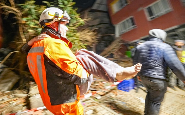 Un membro della Catena di Salvataggio porta in braccio una ragazza appena salvata.