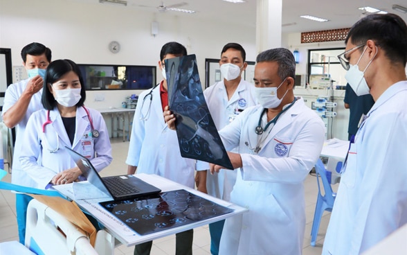 Visite matinale dans un hôpital pour enfants Kantha Bopha. Un médecin examine la radiographie d’un patient.