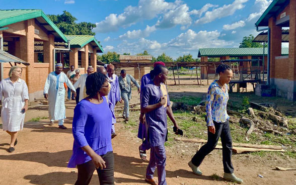 Patricia Danzi walking alongside some Beninese men and women.