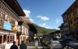 Uno svizzero e due bhutanesi camminano insieme lungo una strada della capitale Thimphu