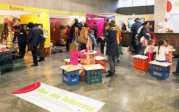 Des gens regardent l’exposition spéciale de la DDC «Voir plus loin que le bord de son assiette».