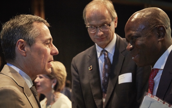 Ignazio Cassis and Gilbert F. Houngbo in discussion. Pio Wennubst is standing nearby.