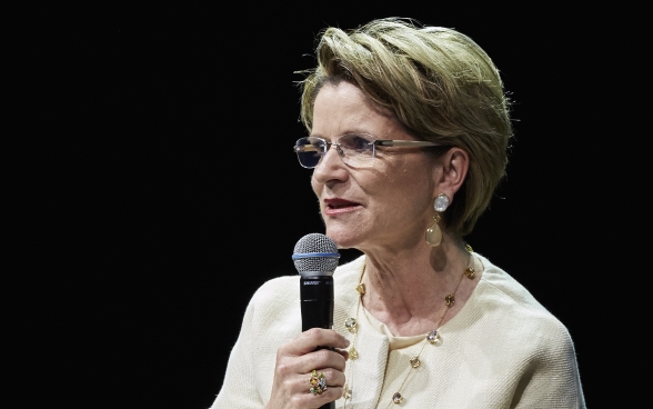 Marie-Gabrielle Ineichen-Fleisch sitting on stage and speaking into a microphone.