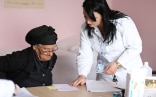 Una donna anziana riceve una prescrizione in una struttura sanitaria in Albania.