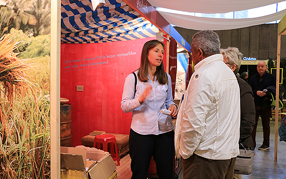 Une collaboratrice de la DDC parle avec deux visiteurs de l'OLMA 2015.