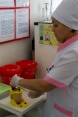 Zulfia Djumaeva is using a needle cutter to destroy a used syringe. © SDC