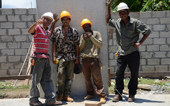 Quattro operai haitiani in posa per una foto sul cantiere. © DSC 