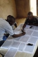 Des hommes reportent des données sur une carte.