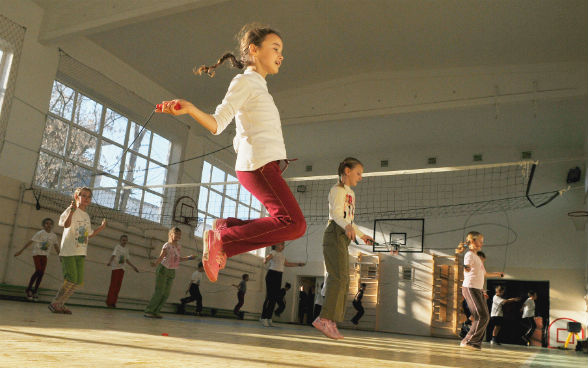 Des enfants font de la corde à sauter.