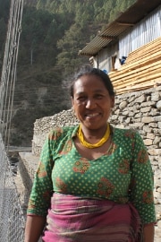 Sanu Maya Tamang debout devant le pont.