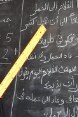 Une jeune mère, tenant une règle dans la main et lisant ce qui est écrit sur le tableau noir, bénéficie de l’apprentissage dans un centre d’alphabétisation à Oum Hadjer, dans la région du Batha, au Tchad.
