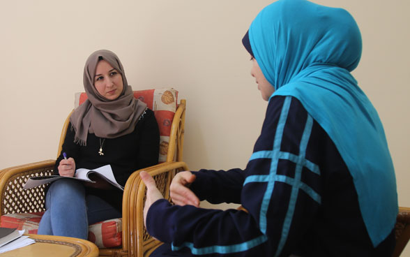A therapist counselling a patient in a consultation room.