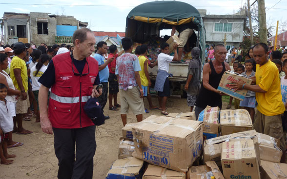 Un membro del Corpo svizzero di aiuto umanitario controlla la distribuzione dei beni di prima necessità. 