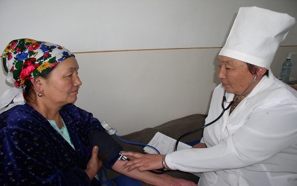 : A woman doctor examining a woman patient.
