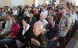 Women and men assembled in a community hall.
