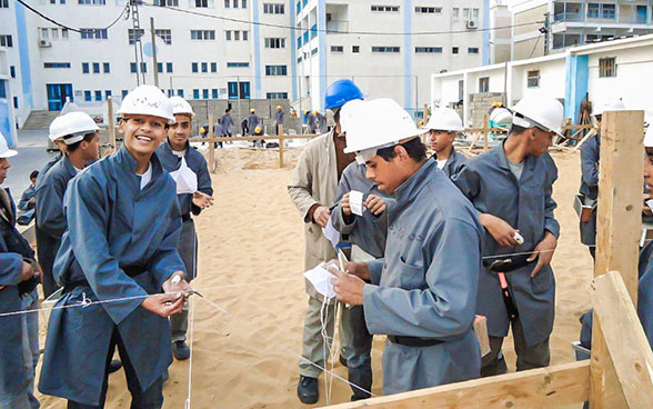 Des apprentis ouvriers du bâtiment sur un chantier.