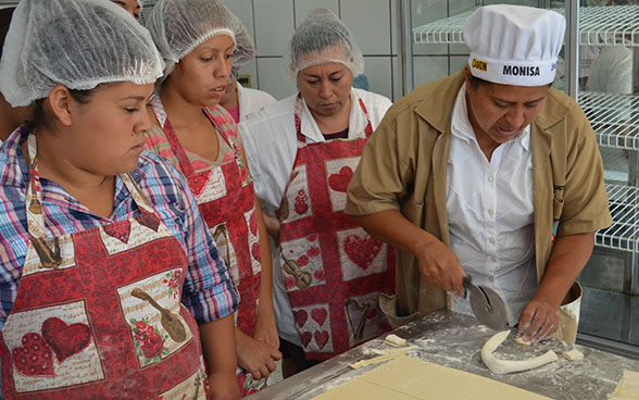 Angehende Bäckerinnen-Konditorinnen folgen den Erklärungen einer Lehrmeisterin