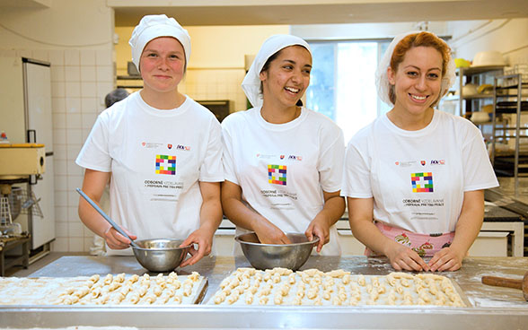 Trois apprenties en boulangerie-pâtisserie fabriquent des petits croissants 