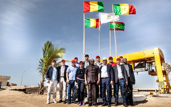 Des représentants haut placés de gouvernements d’Asie centrale et d’Afrique de l’Ouest réunis devant une conduite d’eau de grand diamètre. 