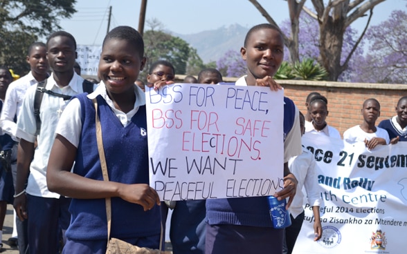 Descrizione: Giovani marciano con alcuni manifesti per la pace e per elezioni pacifiche in Malawi.