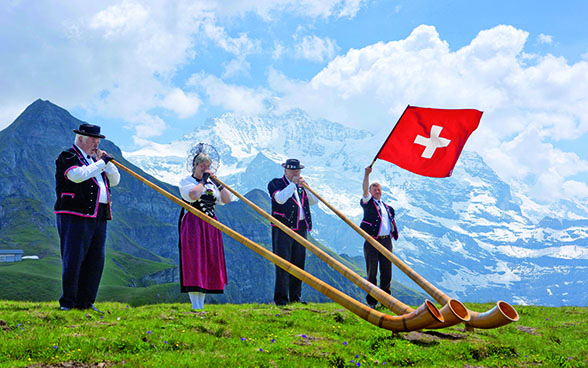 Alphornbläser und Fahnenschwinger vor dem Jungfraumassiv.