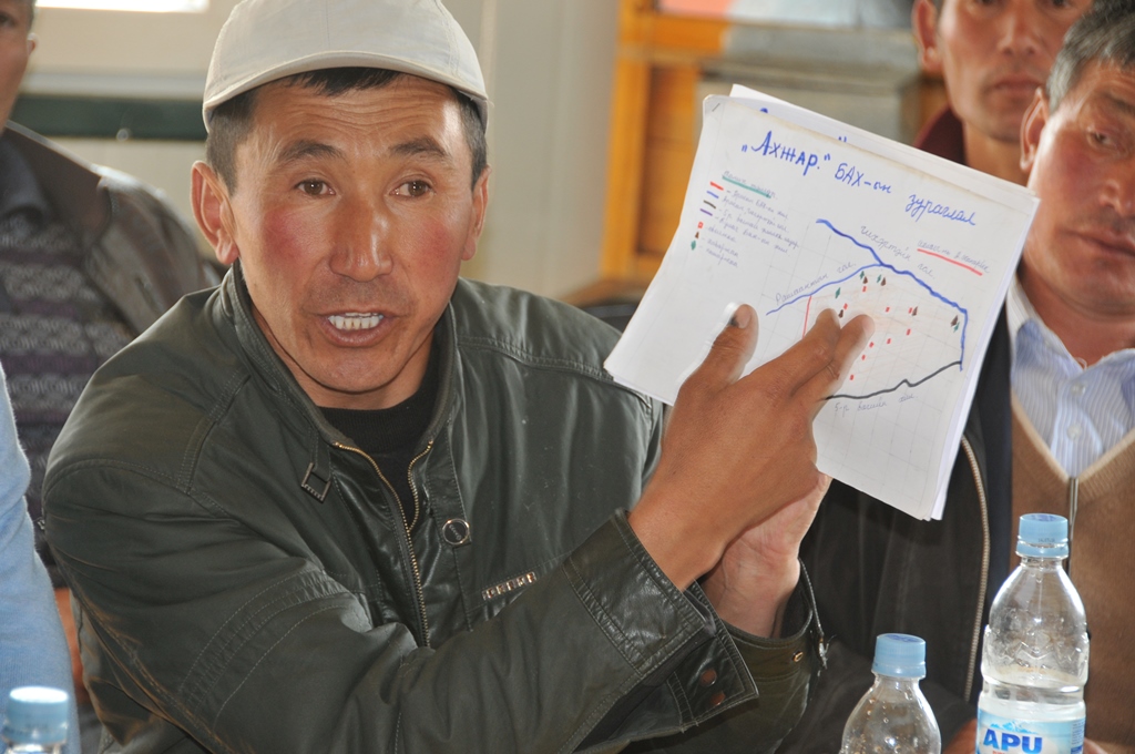 Un hombre mostrando un gráfico en una asamblea.