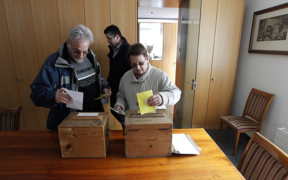 Un hombre y una mujer votando.