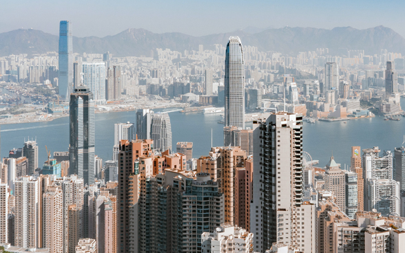 L'immagine mostra Hong Kong e i suoi edifici da una prospettiva a volo d'uccello.