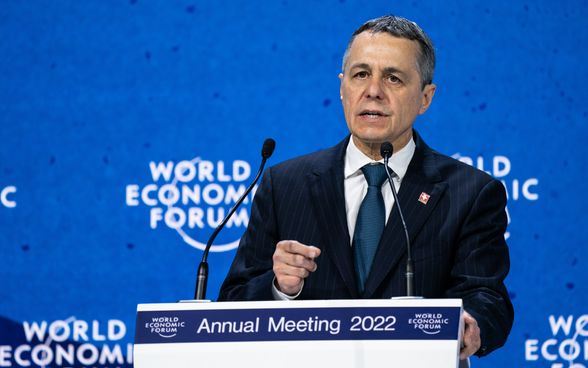 Il Presidente della Confederazione Cassis pronuncia il suo discorso dal leggio sul palco. Sullo sfondo c'è un muro blu con la scritta " World Economic Forum".