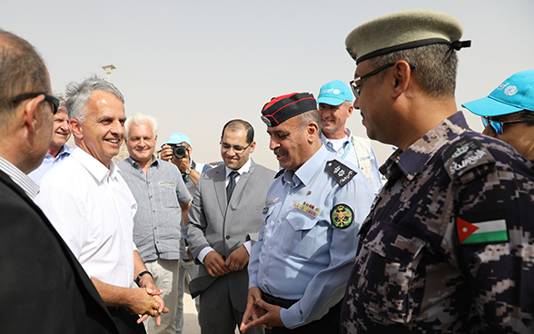 Bundesrat Burkhalter steht in einer Gruppe von Männern bei seiner Ankunft im Flüchtlingslager Azraq.