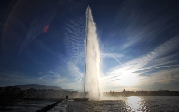 Der Jet d'eau vor der Genfer Skyline bei Sonnenaufgang