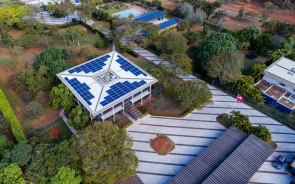 Aerial view of the embassy grounds in Brasilia showing the individual buildings fitted with solar panels and the embassy's large garden.