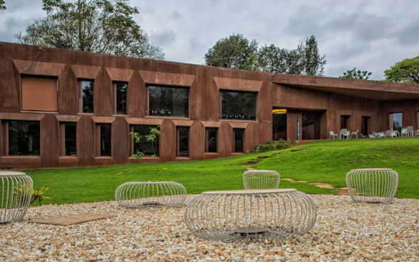 L’edificio di colore rossiccio dell’Ambasciata di Svizzera a Nairobi con in primo piano panchine di forma stilizzata.